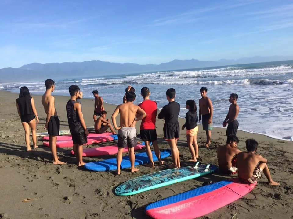 Students getting a briefing on the beach before heading into the waves